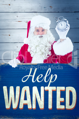 Composite image of santa claus holding alarm clock and sign