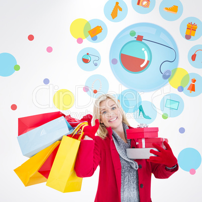 Composite image of festive blonde holding many gifts