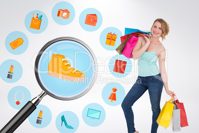 Composite image of smiling blonde woman standing with shopping b