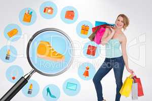 Composite image of smiling blonde woman standing with shopping b