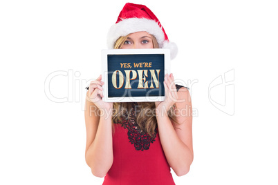 Composite image of festive blonde showing a tablet