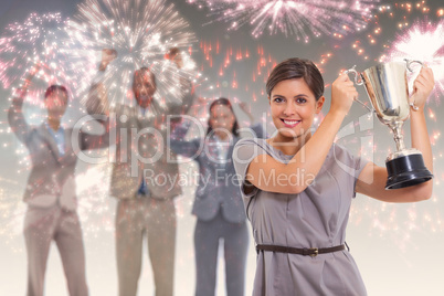 Composite image of woman holding up a cup with enthusiastic cowo