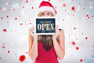 Composite image of festive blonde showing a tablet