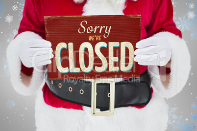 Composite image of mid section of santa claus holding page