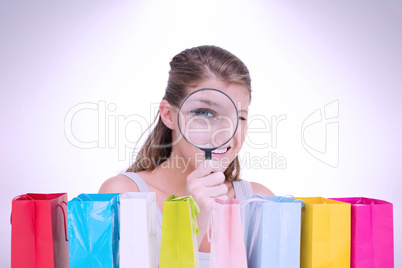 Composite image of woman looking through a magnifying glass