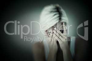 Composite image of sad blonde woman crying with head on hands