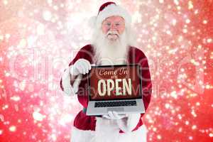 Composite image of santa claus presents a laptop