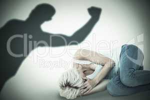 Composite image of sad blonde woman lying on the floor