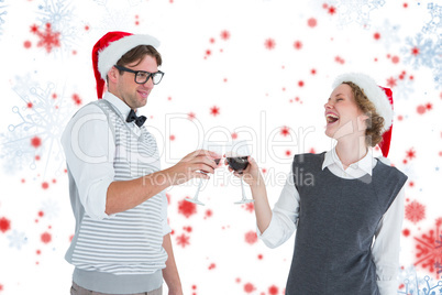 Composite image of happy geeky hipster couple drinking red wine