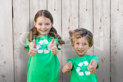 Composite image of happy siblings in green with thumbs up