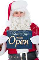 Composite image of cheerful santa claus holding page