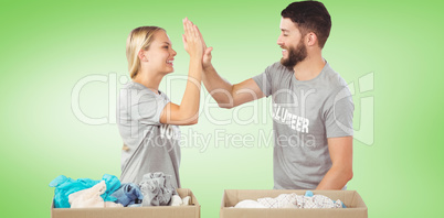 Composite image of happy volunteer doing high five