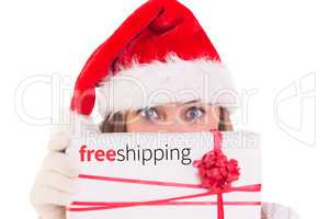 Composite image of festive blonde holding a gift