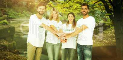 Composite image of group portrait of happy volunteers with hands