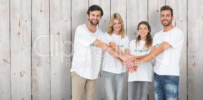 Composite image of group portrait of happy volunteers with hands