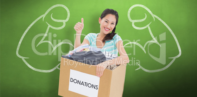 Composite image of woman with clothes donation gesturing thumbs