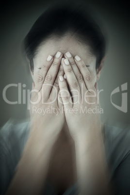 Composite image of sad woman hiding her face