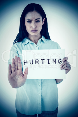 Composite image of woman showing card and saying stop