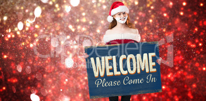 Composite image of festive redhead in foam beard holding poster