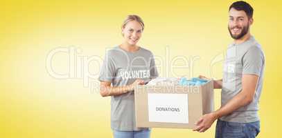 Composite image of portrait of smiling volunteer holding clothes
