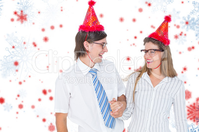 Composite image of happy geeky hipster couple with party hat