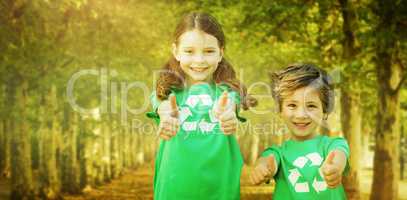 Composite image of happy siblings in green with thumbs up