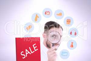 Composite image of geeky businessman looking through magnifying