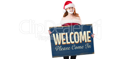 Composite image of festive redhead in foam beard holding poster