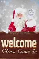 Composite image of santa claus holding alarm clock and sign