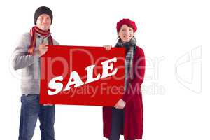 Composite image of couple holding a large sign