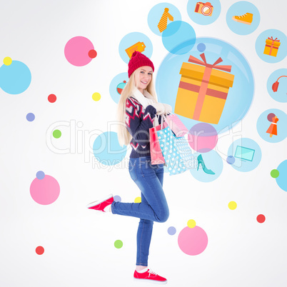 Composite image of festive blonde holding shopping bags