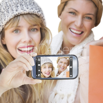 Composite image of hand holding smartphone showing