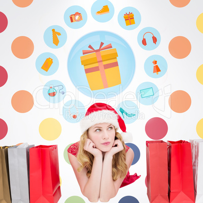Composite image of thoughtful woman lying between shopping bags