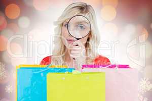 Composite image of fair-haired woman looking through a magnifyin