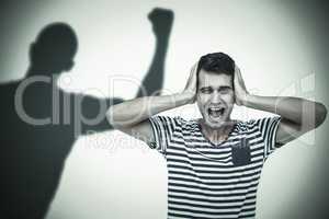 Composite image of handsome man screaming while covering ears