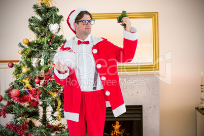 Composite image of geeky hipster in santa costume looking at mis