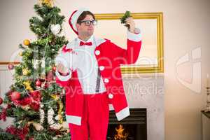 Composite image of geeky hipster in santa costume looking at mis