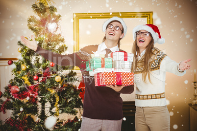 Composite image of smiling man and woman wearing santa hats and