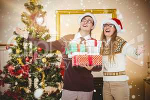 Composite image of smiling man and woman wearing santa hats and