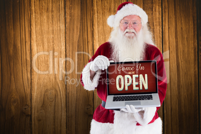 Composite image of santa claus presents a laptop