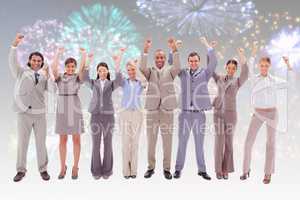 Composite image of happy business team raising their arms