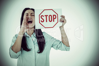 Composite image of shouting brunette holding page