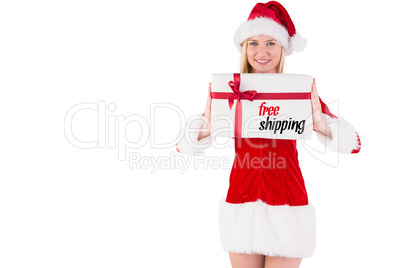 Composite image of festive blonde holding a gift