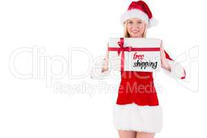 Composite image of festive blonde holding a gift