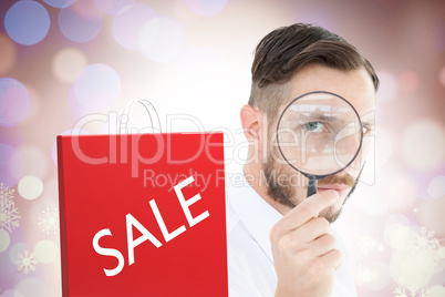 Composite image of geeky businessman looking through magnifying