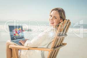 Composite image of gorgeous blonde sitting on deck chair using l