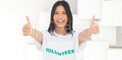 Composite image of woman wearing volunteer tshirt giving thumbs