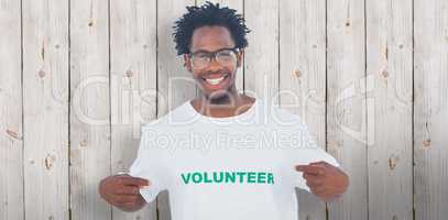 Composite image of handsome man pointing to his volunteer tshirt