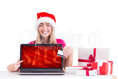 Composite image of festive blonde shopping online with laptop