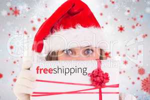 Composite image of festive blonde holding a gift